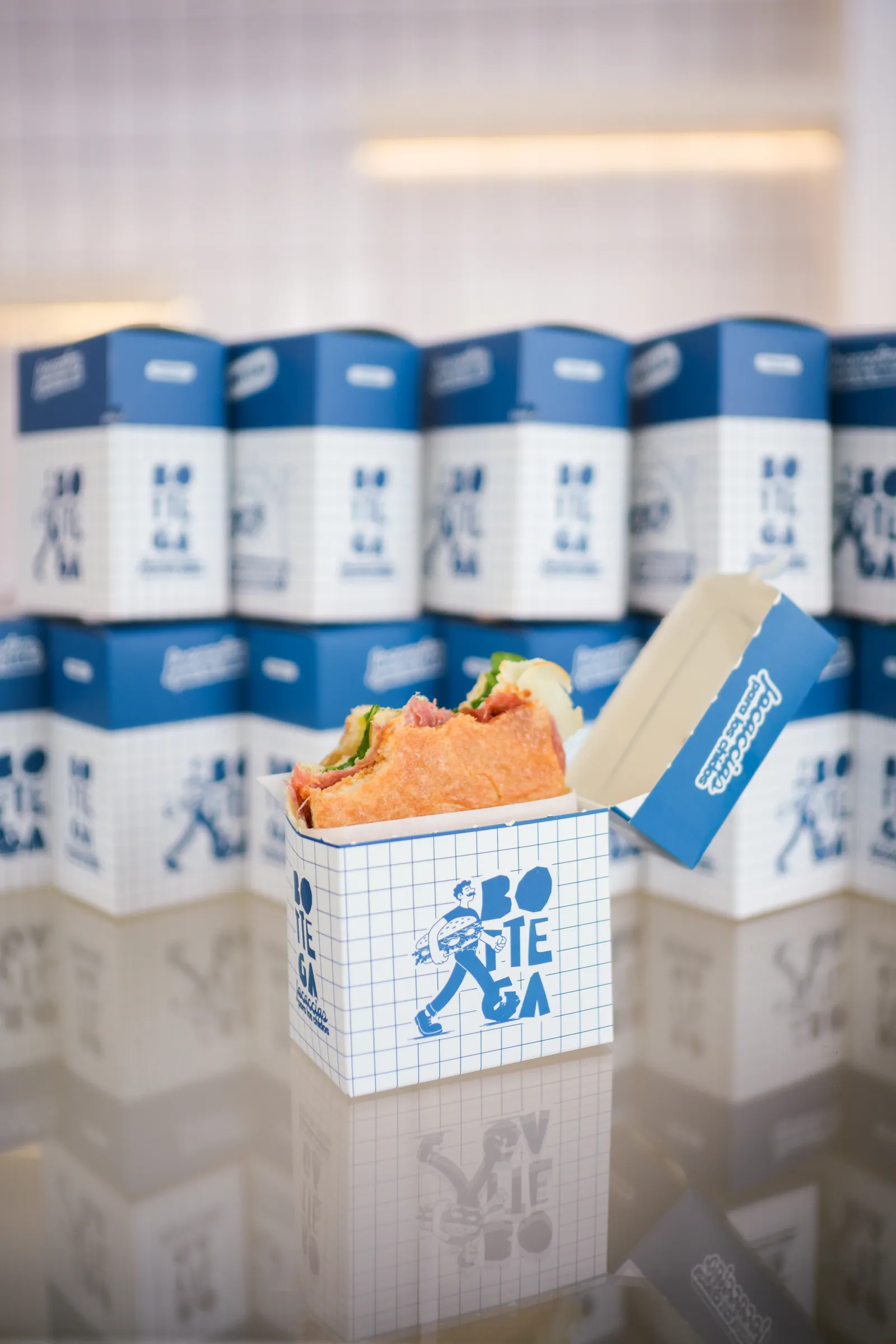 Focaccia en su caja frente al muro de cajas